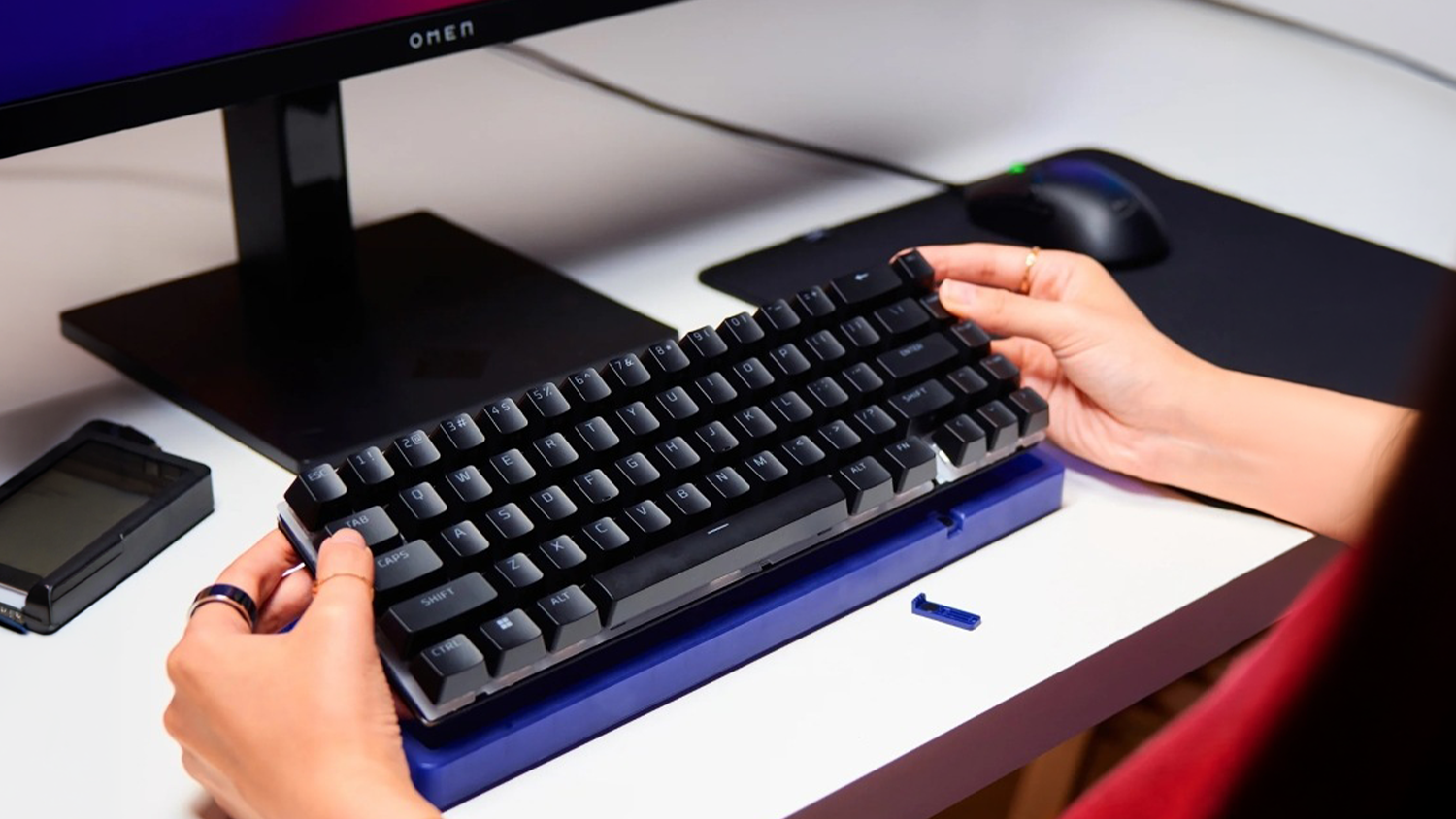 Hráč si mění kryt klávesnice HyperX Origins 2 65 Housing před monitorem