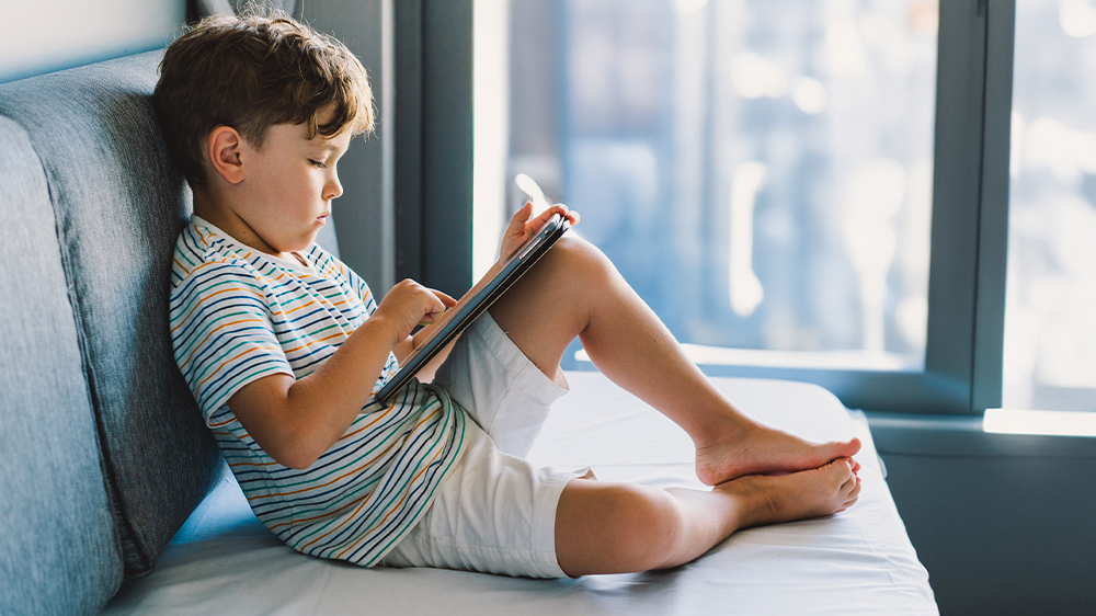 Chlapec hraj&iacute;c&iacute; si na tabletu na pohovc_02