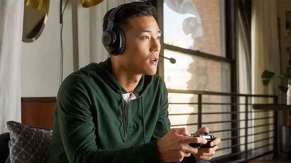 Muž s herními sluchátky JBL Quantum 100 Blue hraje PlayStation_02