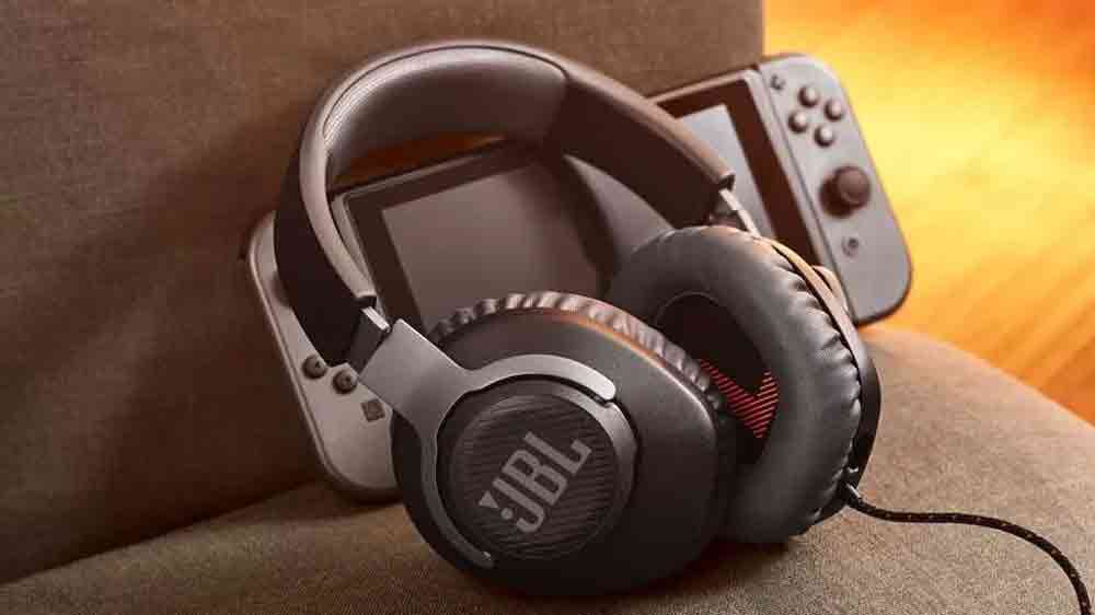 Herní sluchátka JBL Quantum 100 White vedle herní konzole_03