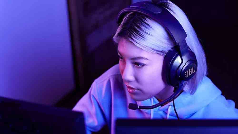Dívka hraje na počítači s herními sluchátky JBL Quantum 400_02