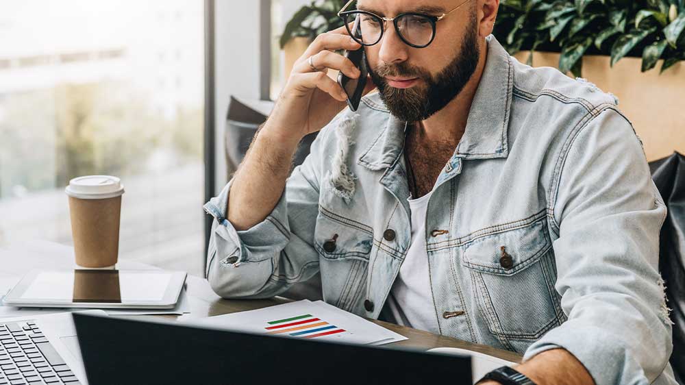 Telefonující muž pracuje na notebooku_02