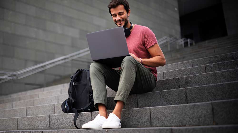 Muž sedící na schodech s notebookem_04