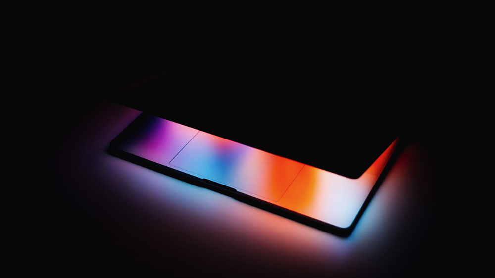 Přivřený notebook s rozsvíceným displejem_3