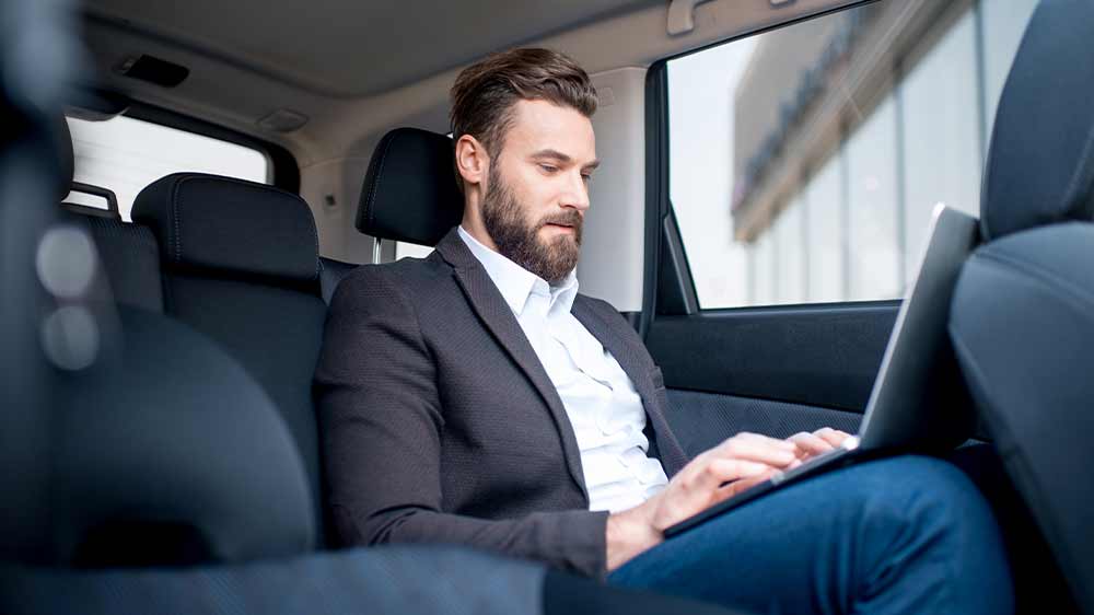 Muž pracuje v autě na notebooku_02
