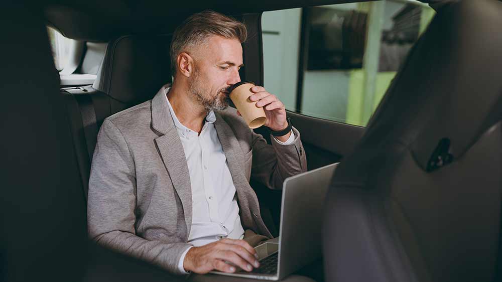 Muž pracuje v autě na notebooku_05