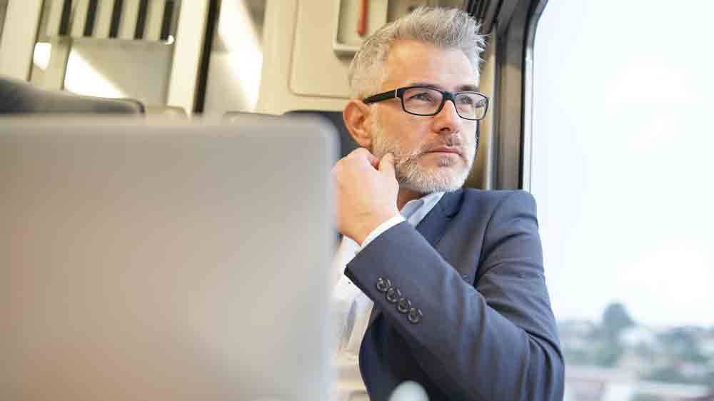 Muž pracuje na notebooku při cestování vlakem_03