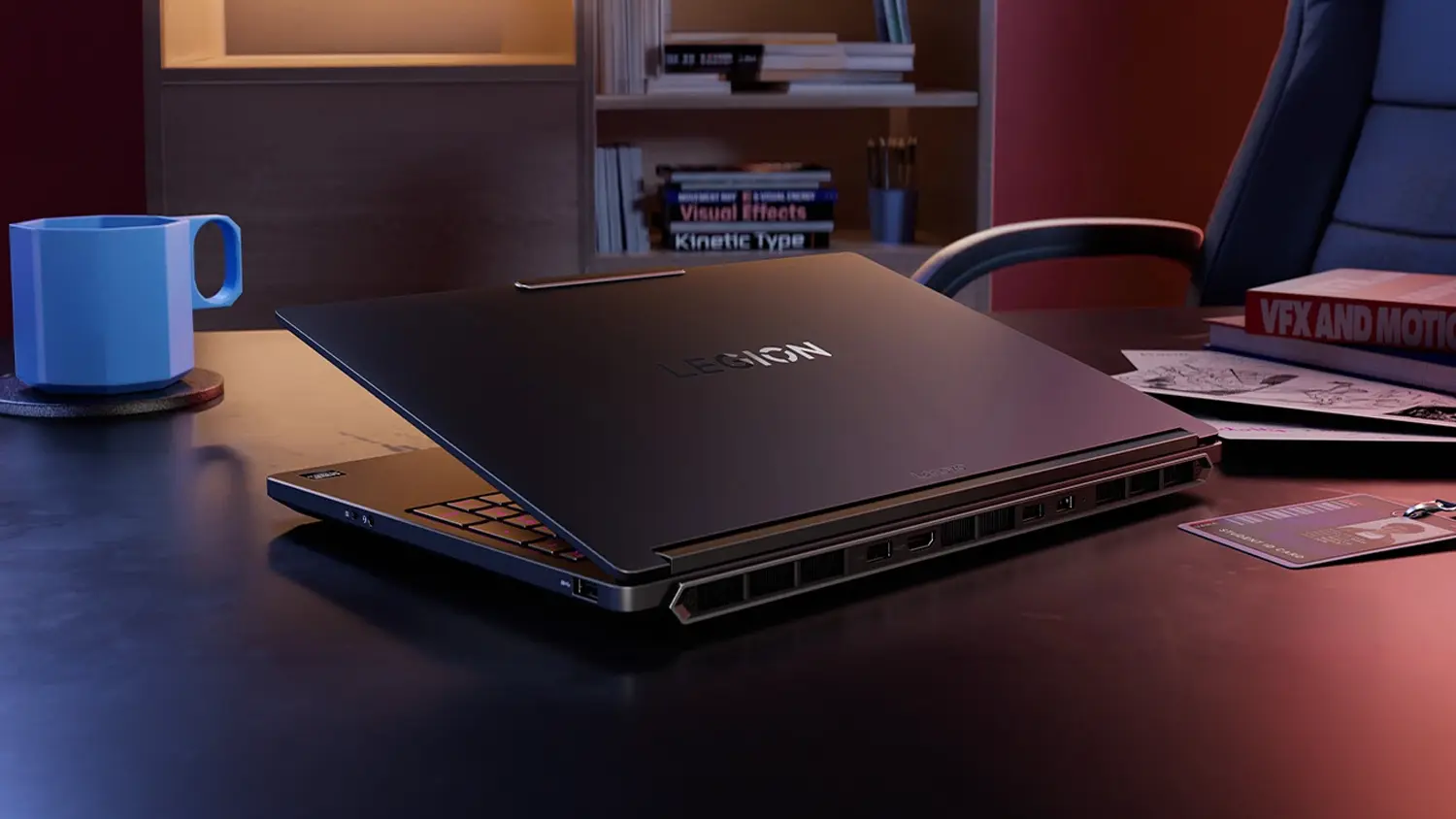 Stůl s hrnkem a pap&iacute;ry vedle notebooku Lenovo