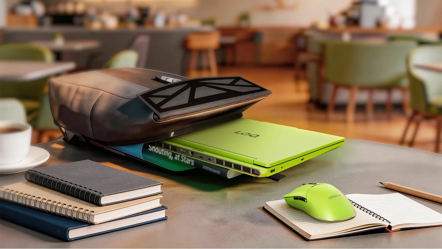Stůl v kav&aacute;rně s batohem a notebookem Lenovo