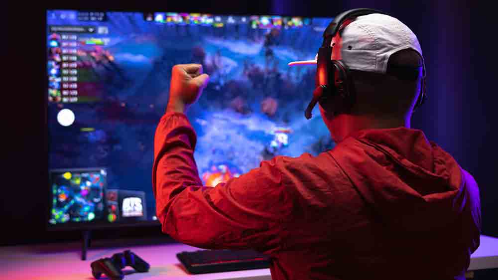 Muž hraje na počítači s bezdrátovými sluchátky_02