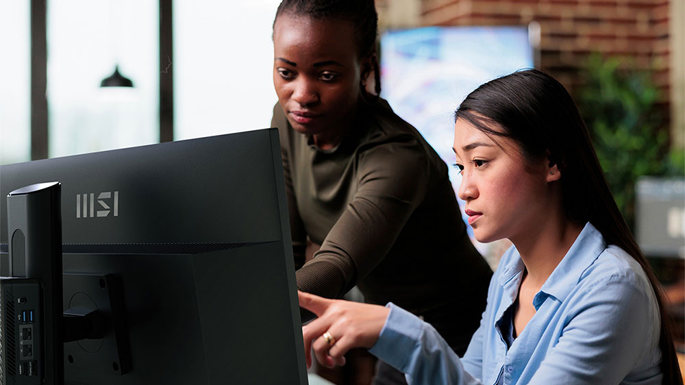 Kolegyně v kanceláři pracující společně na monitoru MSI PRO MP275QPDG_03