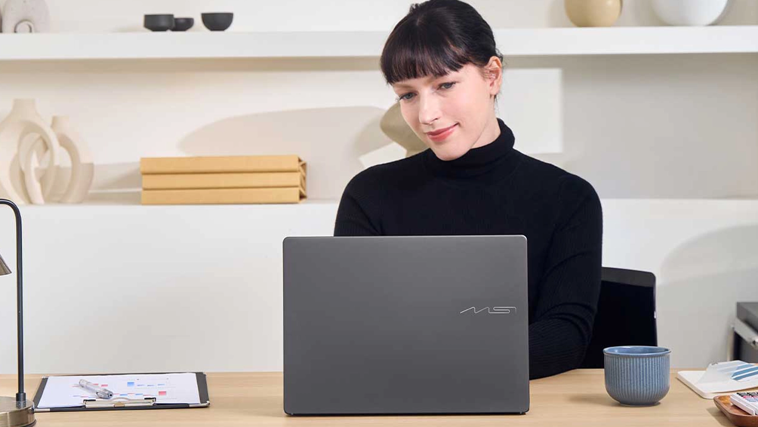 Žena pri pracovnom stole s notebookom MSI