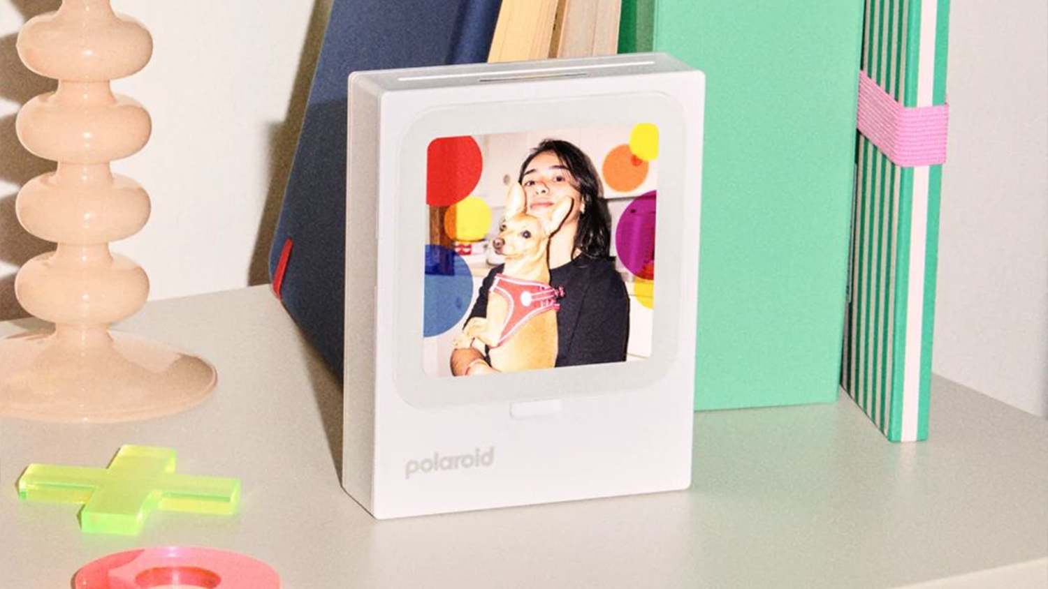 Police s knihami a tiskárna Polaroid jako fotorámeček