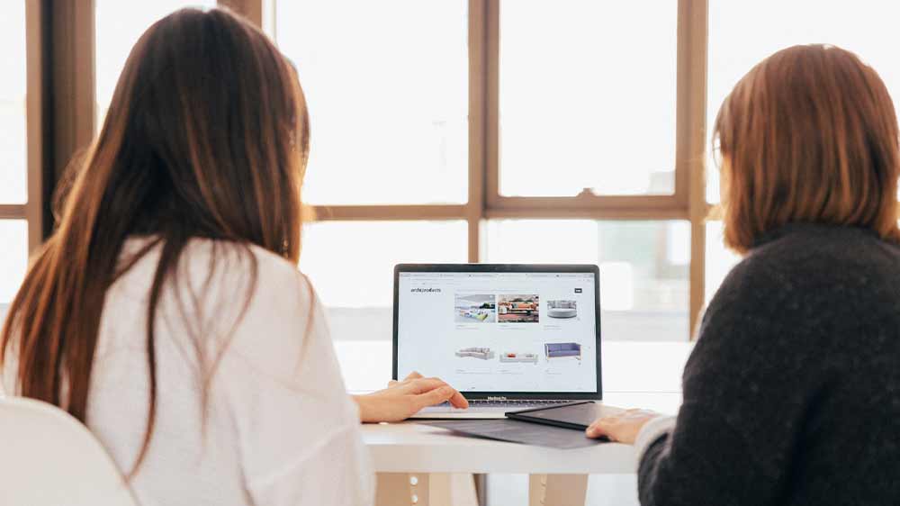 Ženy prohlížející si nabídku gaučů na počítači_02