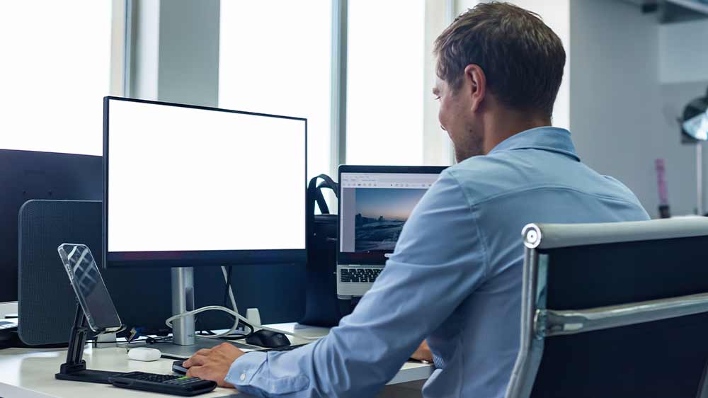 Muž v kanceláři pracuje na počítači_02