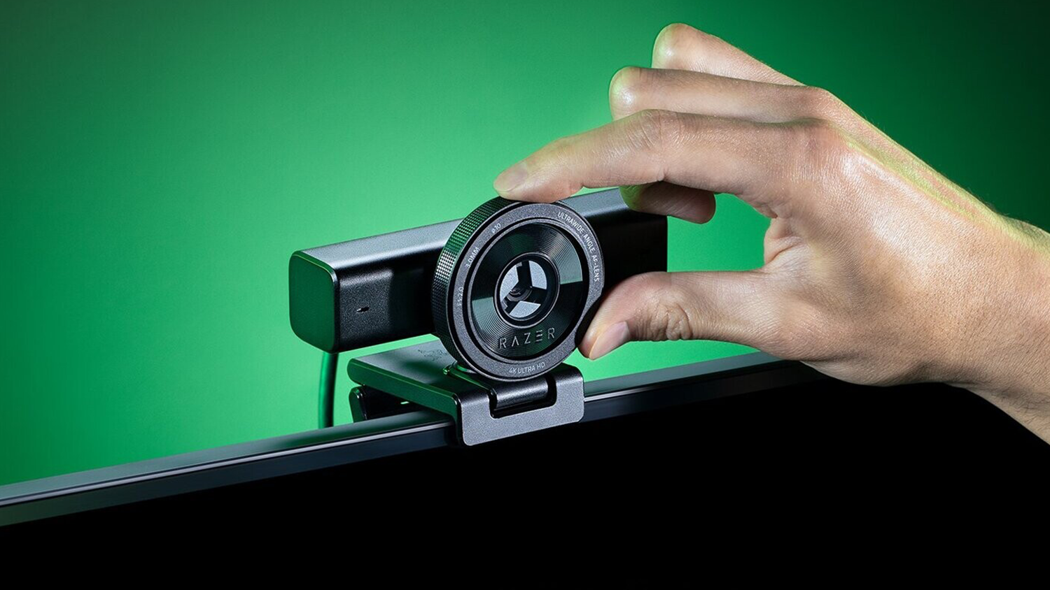 Razer Kiyo V2 X na monitoru a ruka nastavující kameru
