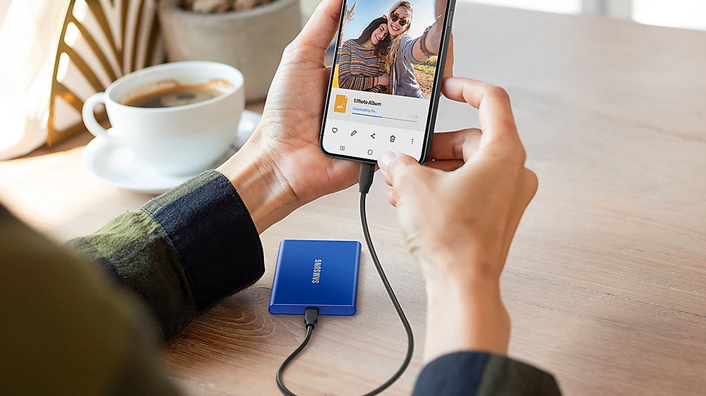 Externí SSD disk Samsung T7 položený na stole připojený k telefonu_02