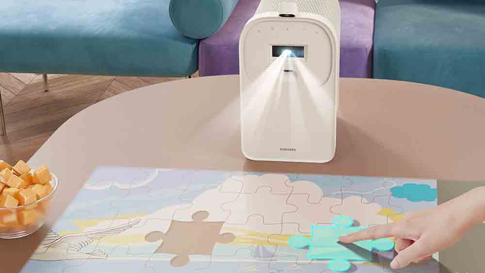 Člověk posouv&aacute; puzzle na obrazu projektoru Samsung Premiere 5_02