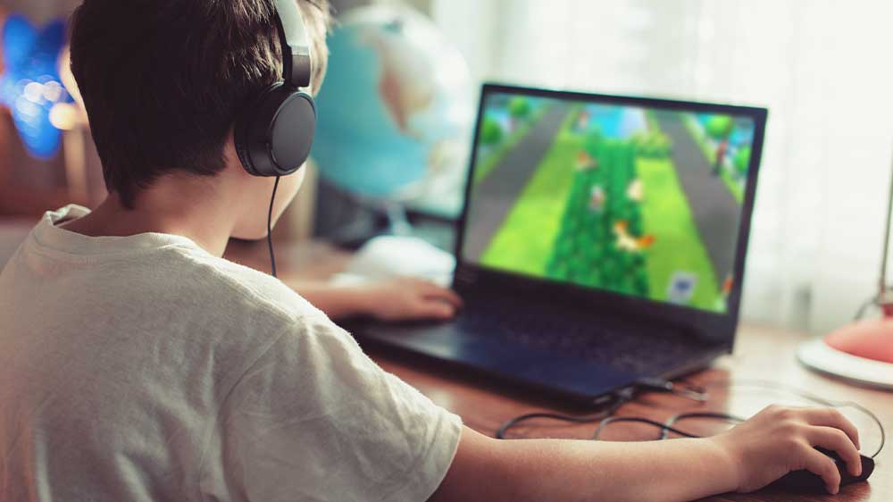 Chlapec hraje hru na notebooku a používá kabelovou myš_03