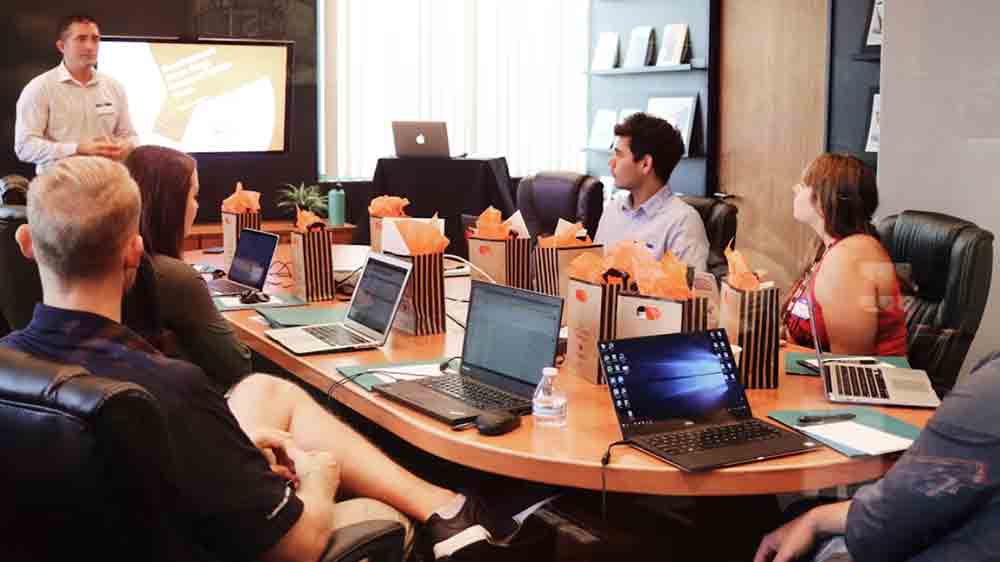 Zasedací místnost s lidmi u stolu s notebooky_02