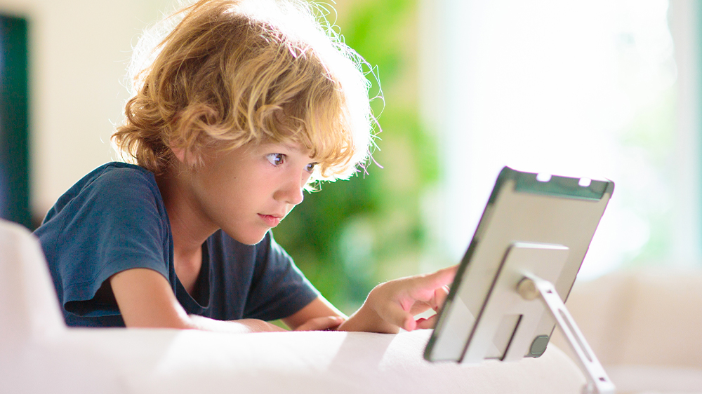 Malý chlapec sleduje filmy na tabletu_04