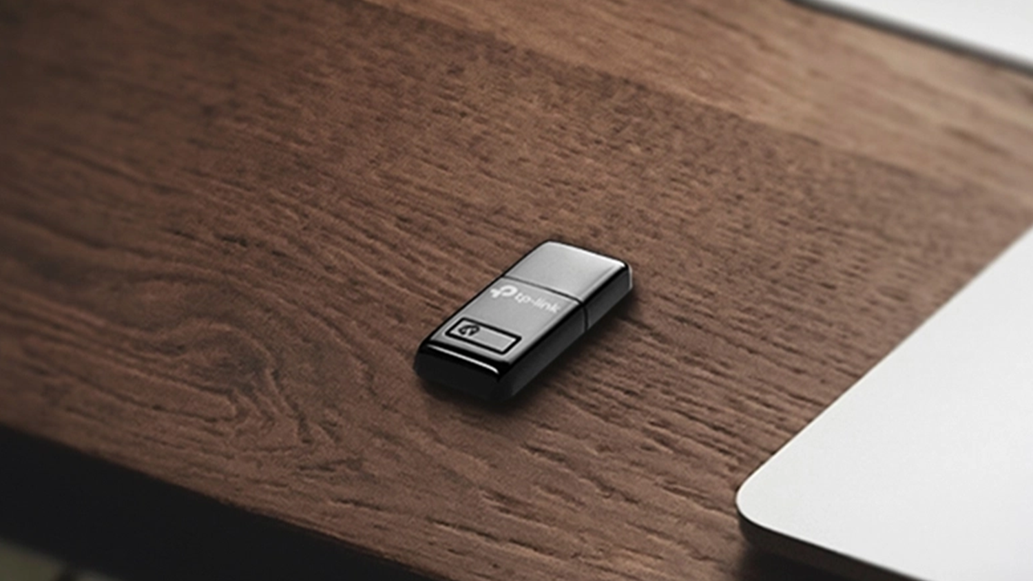 Bezdrátový USB adaptér TP-Link TL-WN823N Mini 300Mbps položený na stole