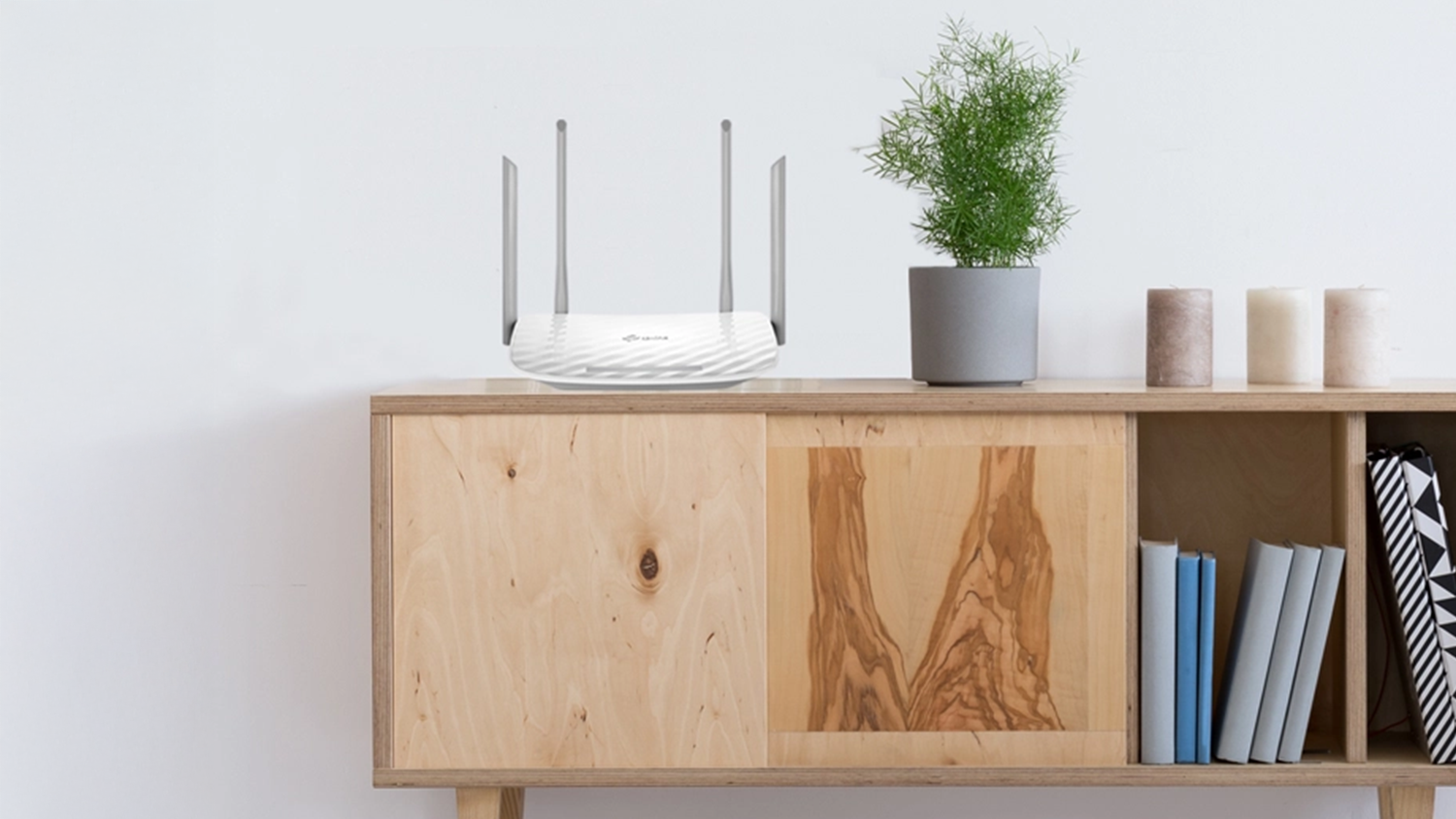 Router TP-Link Archer C50 postaven&yacute; na komodě