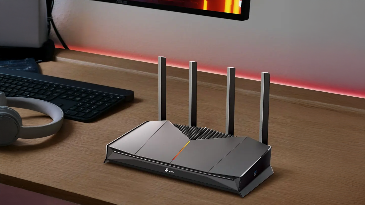 Router TP-Link Archer GE230 vedľa kl&aacute;vesnice a monitora