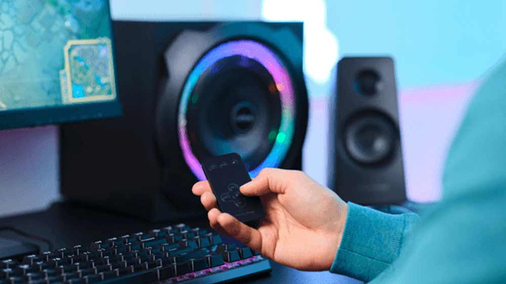 Mužská ruka drží dálkové ovládání od reproduktorů Trust GXT 629 Tytan RGB 2.1_03