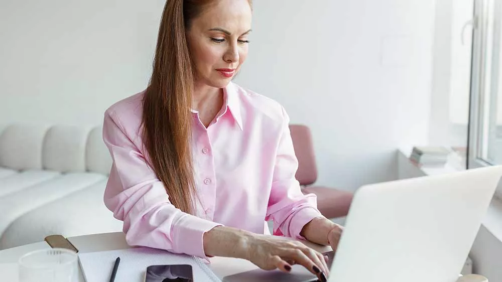 Žena v růžov&eacute; ko&scaron;ili pracuje na notebooku_02