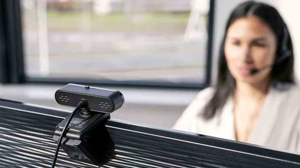 Web kamera snímá ženu v pozadí, sedící u počítače_02