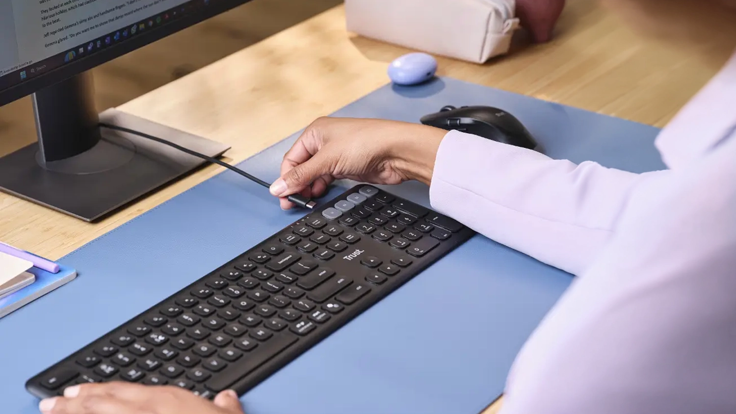 Žena zapája USB-C do klávesnice Trust Vaiya Multi-device