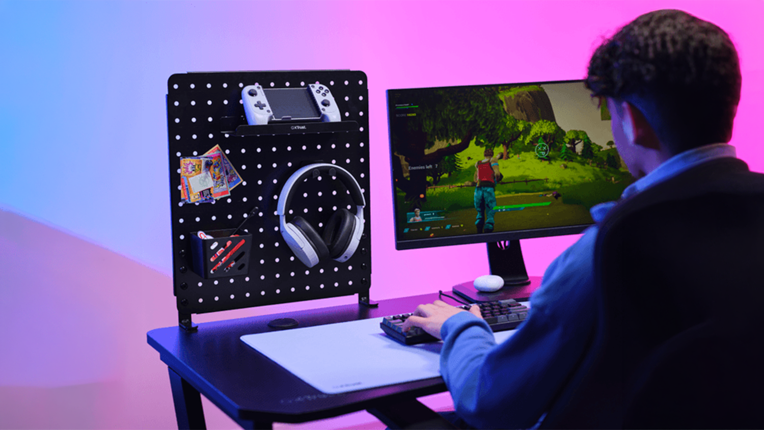 Kluk hraje na PC a na kraji stolu má organizér Trust GXT 724 Vesto Metal