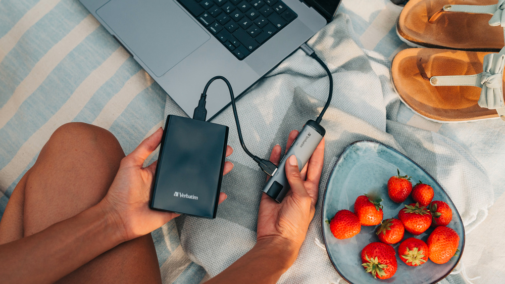 Žena na piknikové dece pouští obsah z externího HDD_03