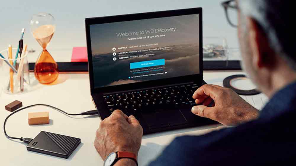 Muž pracující na notebooku s využitím externího HDD disku WD My Passport_02