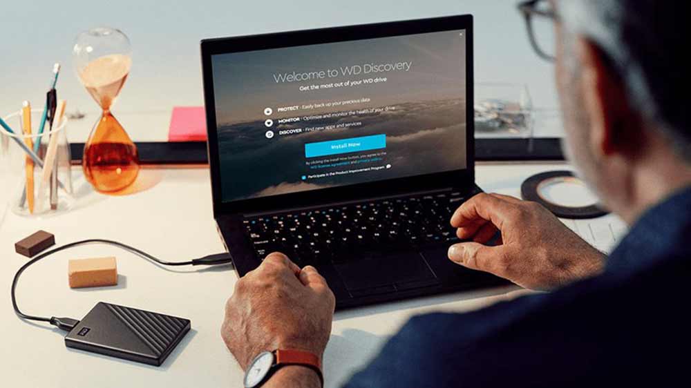 Muž pracuje na notebooku s připojeným externím HDD diskem WD My Passport_02