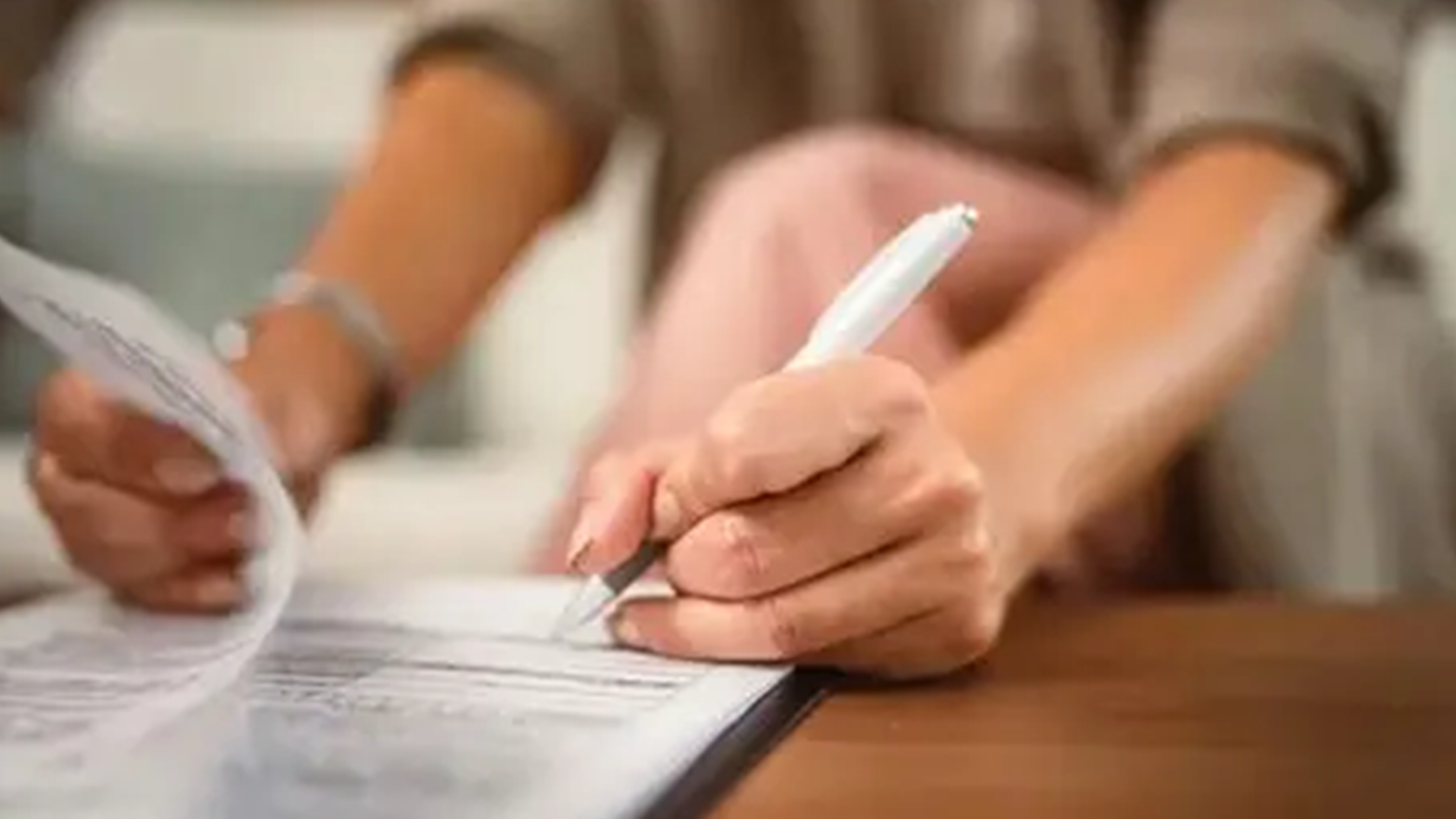 Žena podpisuje vytlačen&eacute; dokumenty