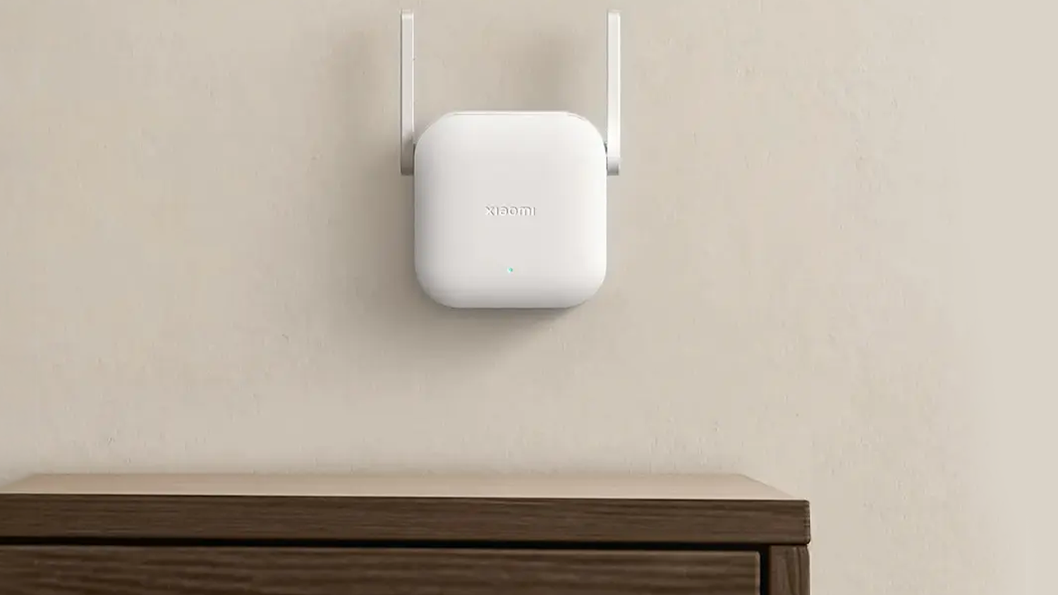 WiFi range extender Xiaomi N300 připojený na stěně nad komodou