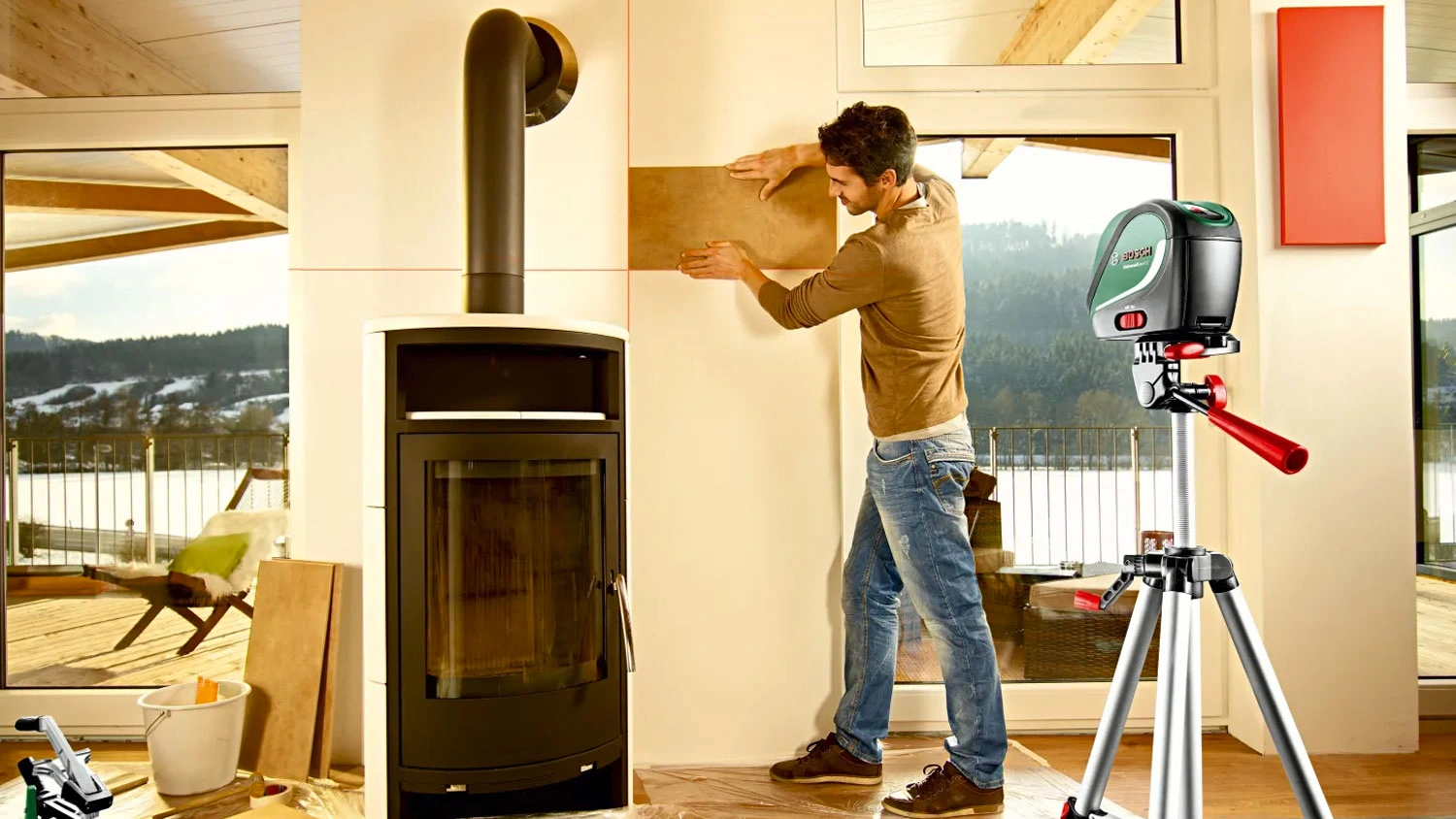 Muž pracuje s měřičem Bosch UniversalLevel 2 na stativu