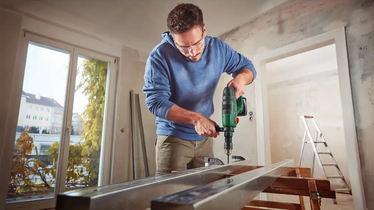 Muž používající akumulátorové vrtací kladivo Bosch UniversalHammer 18V na ocel