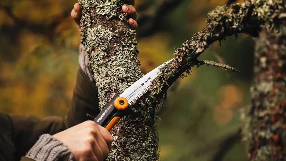 Muž režie vetvu z&aacute;hradnou p&iacute;lou Fiskars Xtract SW73
