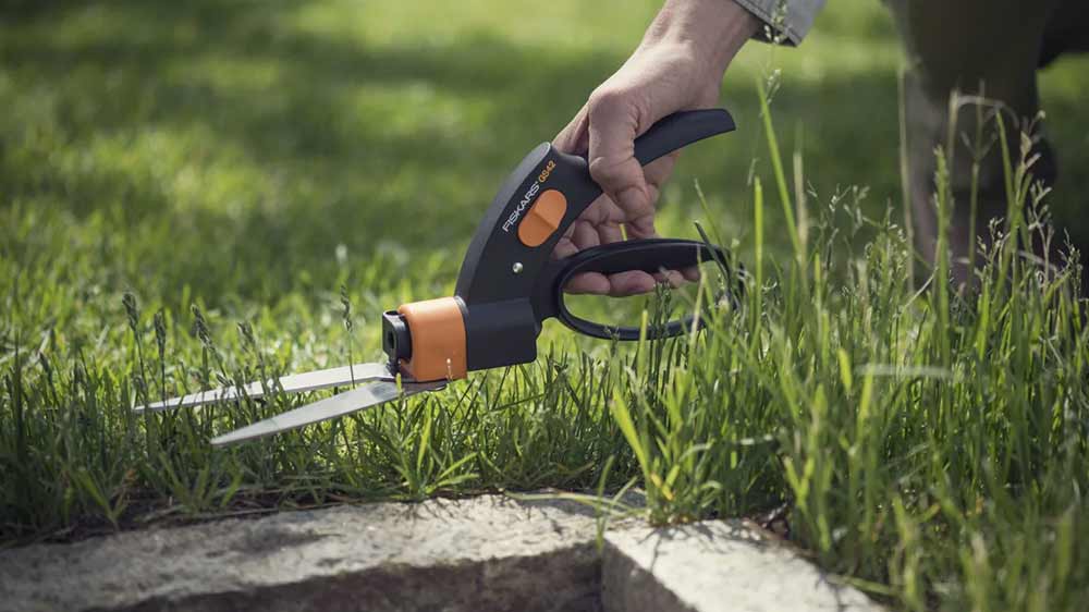 Strihanie trávy vedľa obrubníka nožnicami na trávu Fiskars Servo-System GS42