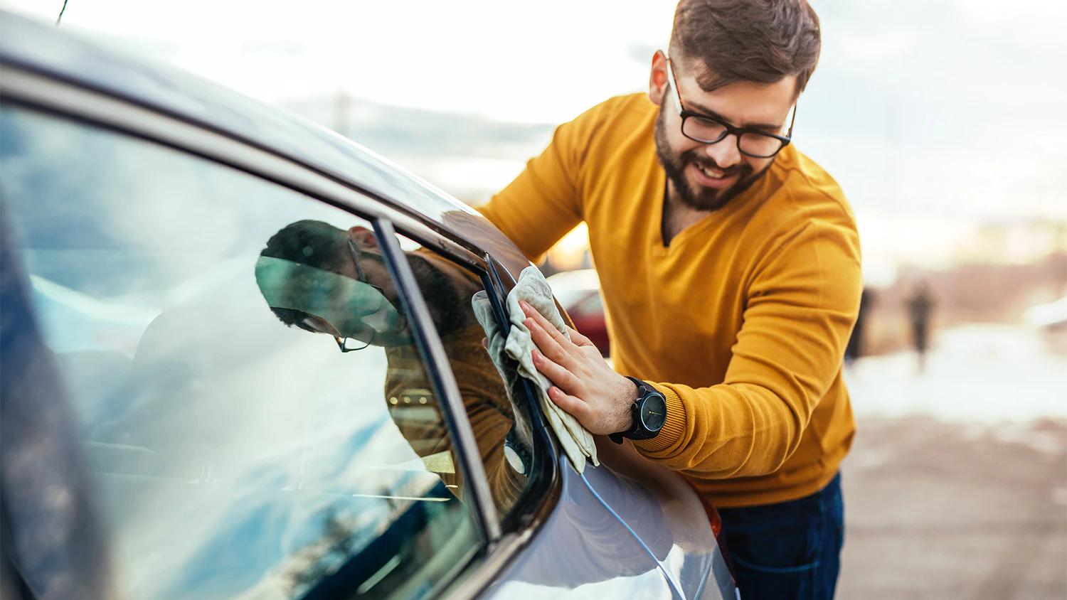 Muž le&scaron;t&iacute; vyčisten&eacute; auto