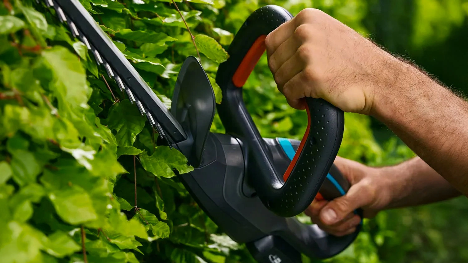 Muž drží nožnice na živý plot GARDENA EasyCut 45/18V