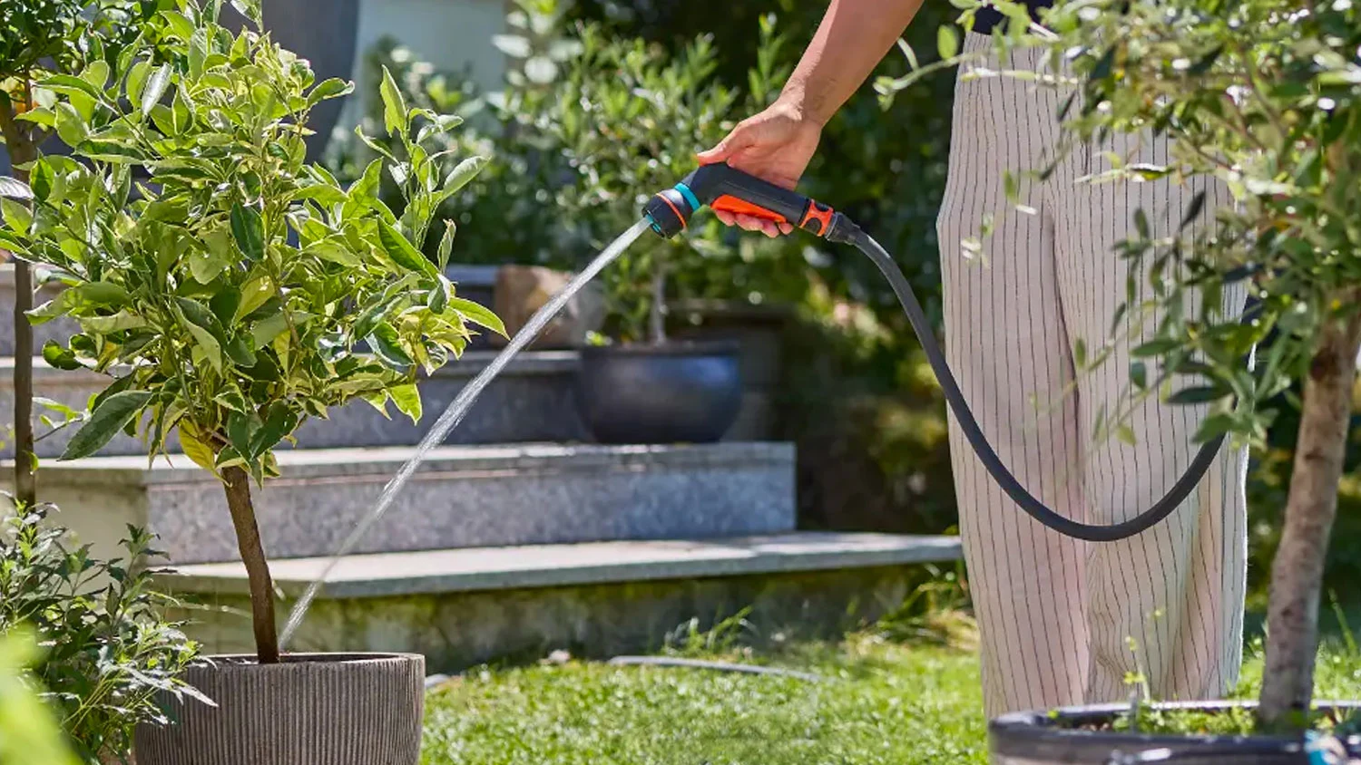 Žena polieva záhradu sprchou Gardena Classic Compact