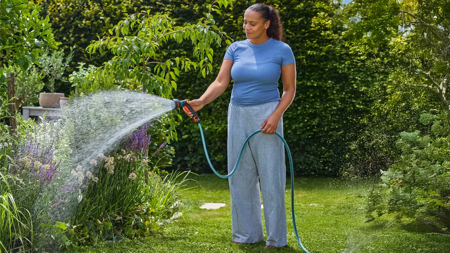 Žena krop&iacute; zahradu pomoc&iacute; sprchy Gardena Classic