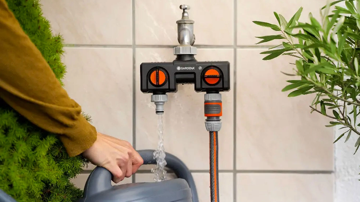 Dvoucestn&yacute; rozdělovač Gardena na kohoutku v zahradě s napojenou hadic&iacute;