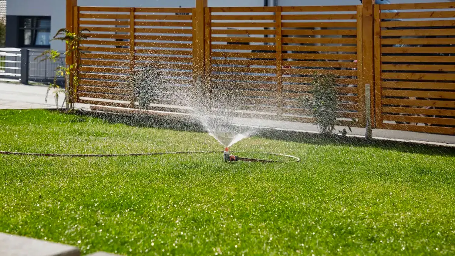 Rozprašovací zavlažovač Gardena v zahradě rozprašuje vodu