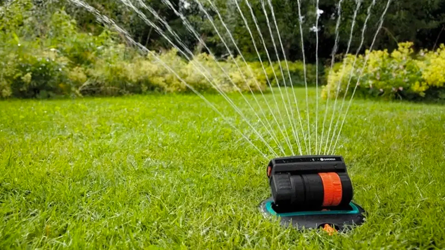 Výkyvný zavlažovač Gardena v zahradě na trávníku