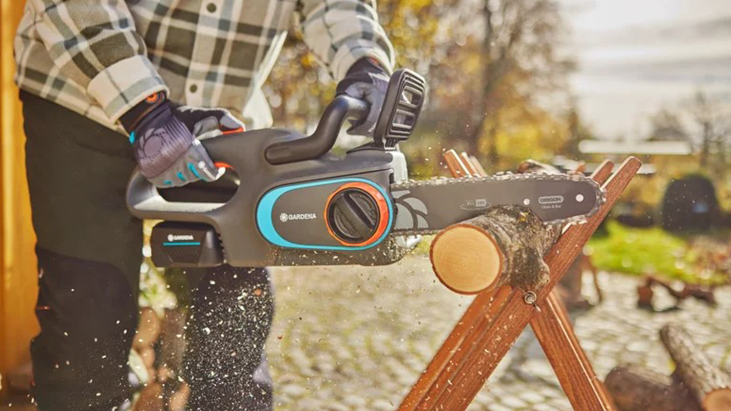 Muž řeže dřevo aku řetězovou pilou PowerSaw Gardena PowerSaw 250/18V P4A